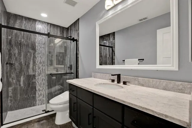 a bathroom with a double vanity sink toilet and shower