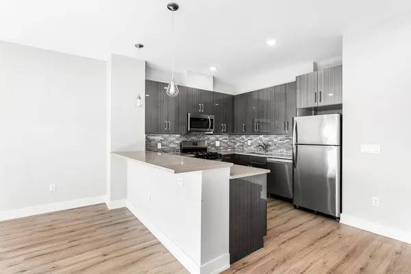 a kitchen with stainless steel appliances granite countertop a refrigerator a sink a stove and oven