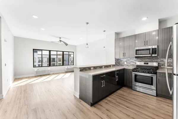 a large kitchen with wooden floors and stainless steel appliances