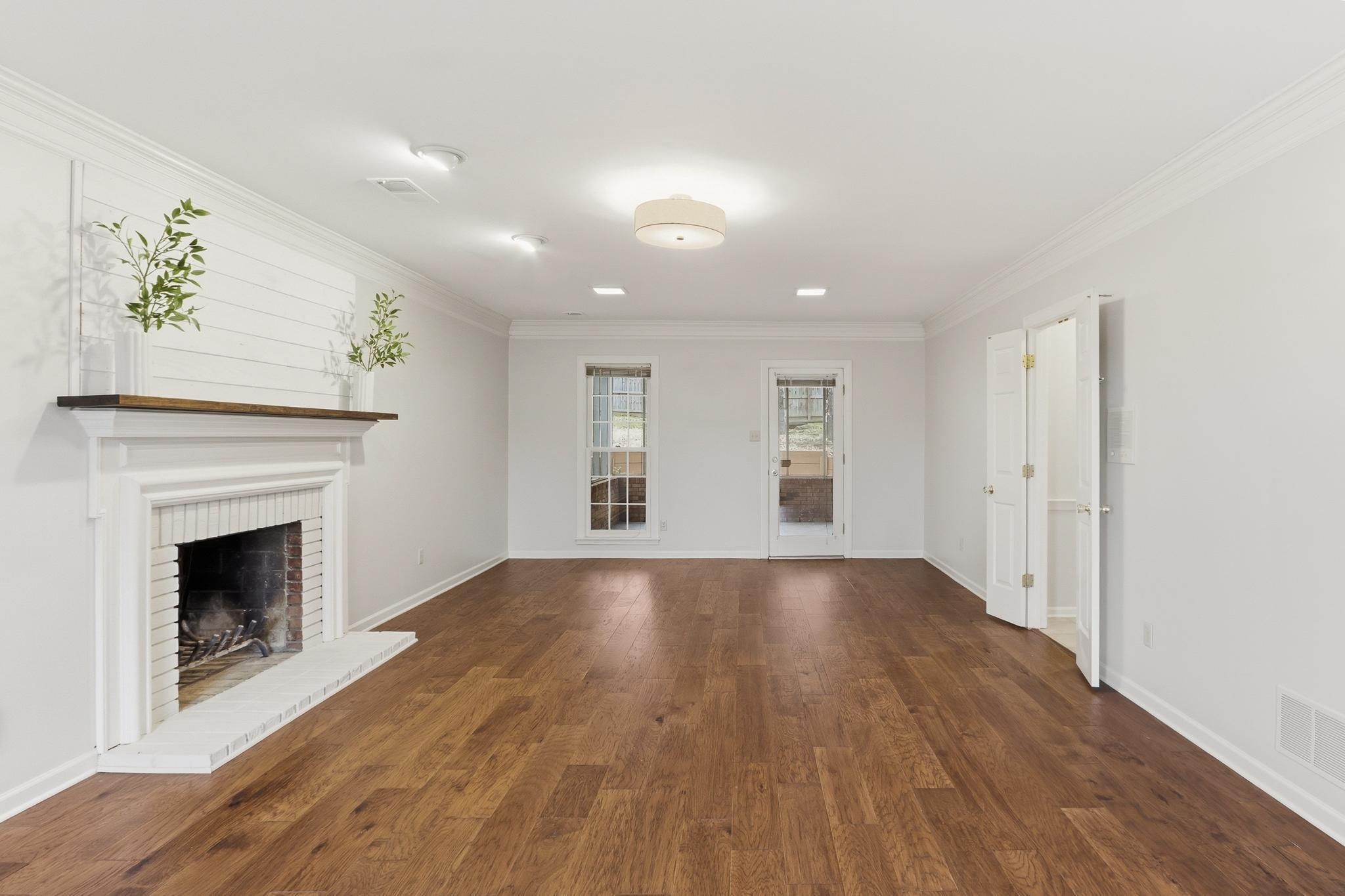 8372 Bazemore Road Cordova, TN 38018 - Photo 4 of 40 a view of an empty room with wooden floor fireplace and a window