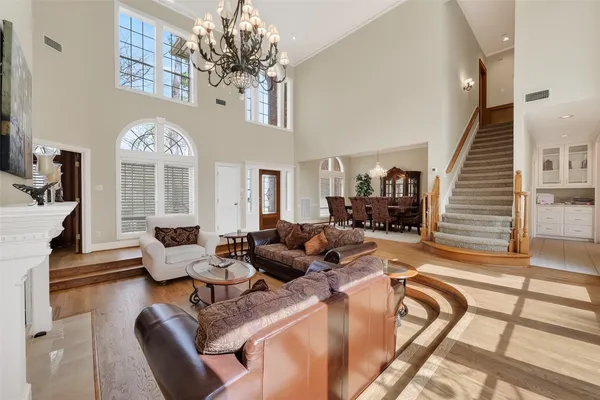 a living room with furniture chandelier and a large window
