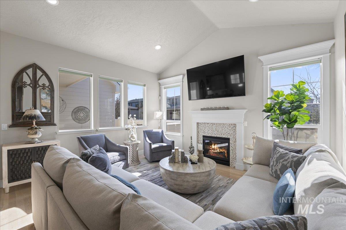 2856 South Wise Way Boise, ID 83716 - Photo 7 of 47 Living area with wood finished floors, lofted ceiling, recessed lighting, a fireplace, and radiator heating unit