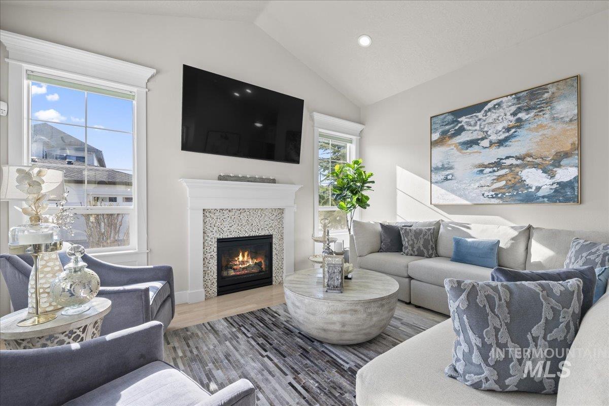 2856 South Wise Way Boise, ID 83716 - Photo 9 of 47 Living area with wood finished floors, lofted ceiling, a tiled fireplace, and recessed lighting