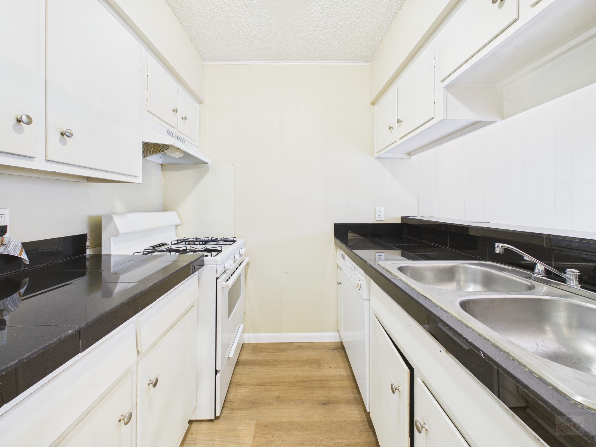 616 West 51st Street, Unit 101 Austin, TX 78751 - Photo 6 of 16 a kitchen with stainless steel appliances granite countertop a sink and dishwasher a stove top oven with wooden floor
