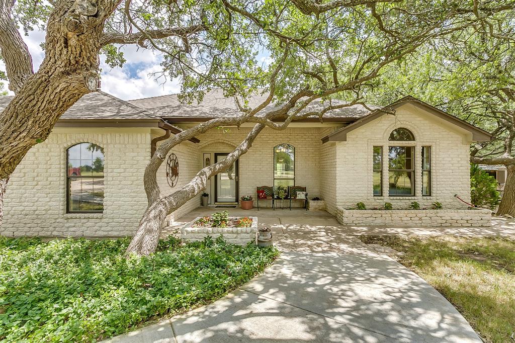 a front view of a house with a garden and yard