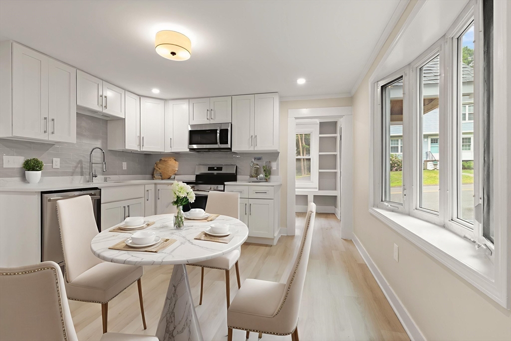 25 Norfolk Street Canton, MA 02021 - Photo 2 of 31 a kitchen with kitchen island a dining table chairs and a refrigerator