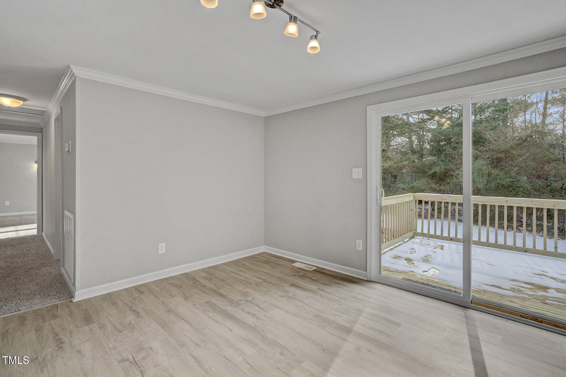 7516 Fox Road Raleigh, NC 27616 - Photo 8 of 31 en empty room with sliding door and wooden floor
