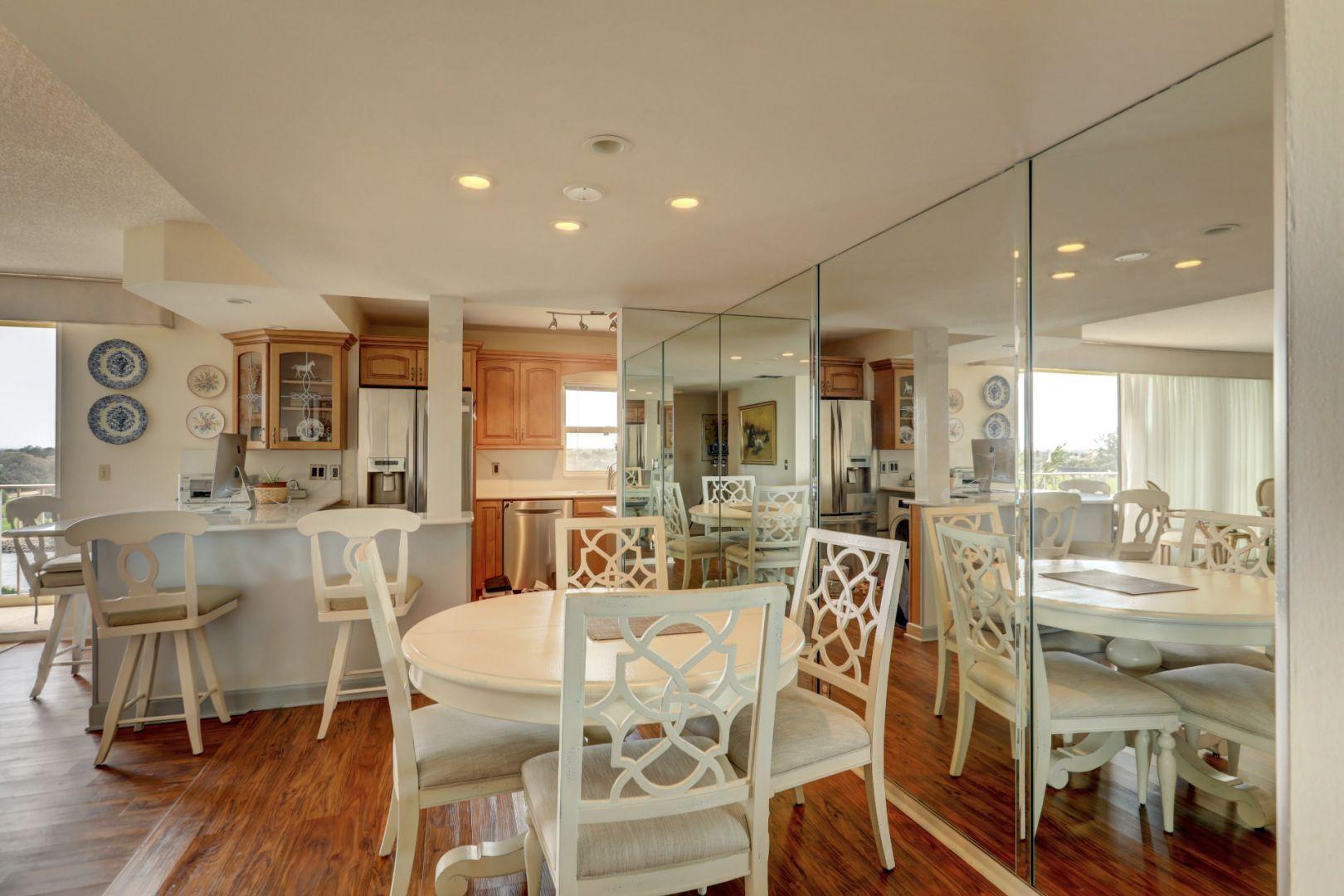 336 Golfview Road, Unit 601 North Palm Beach, FL 33408 - Photo 5 of 28 a view of a dining room and livingroom with furniture wooden floor a rug a flat screen tv a painting and a chandelier