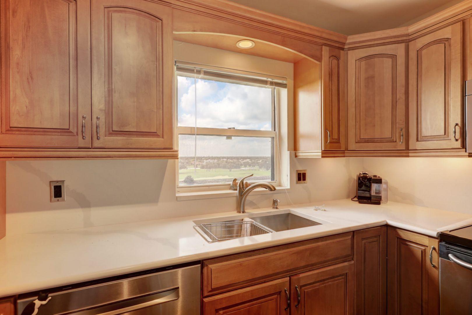 336 Golfview Road, Unit 601 North Palm Beach, FL 33408 - Photo 7 of 28 a kitchen with stainless steel appliances white cabinets and a window