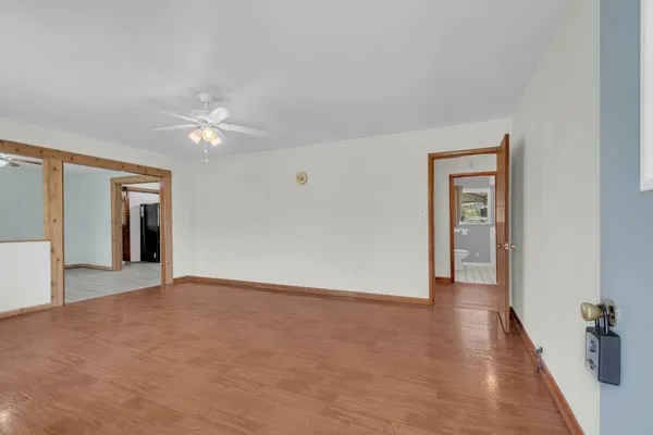 a view of an empty room with a window and wooden floor