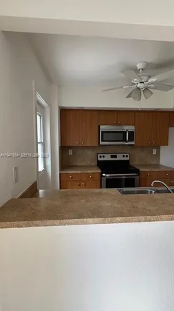 a view of kitchen cabinets microwave and refrigerator
