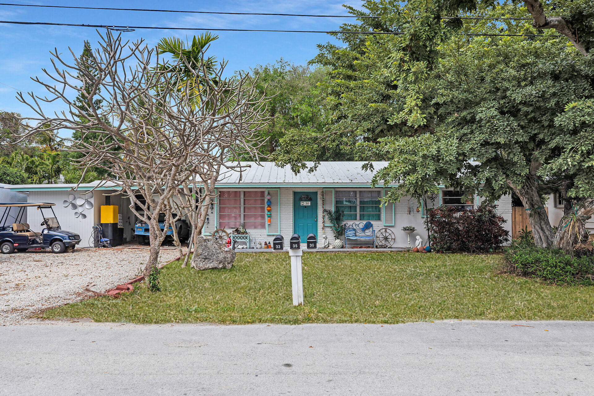 30 Jewfish Avenue Key Largo, FL 33037 - Photo 1 of 43 a front view of a house with a garden and trees