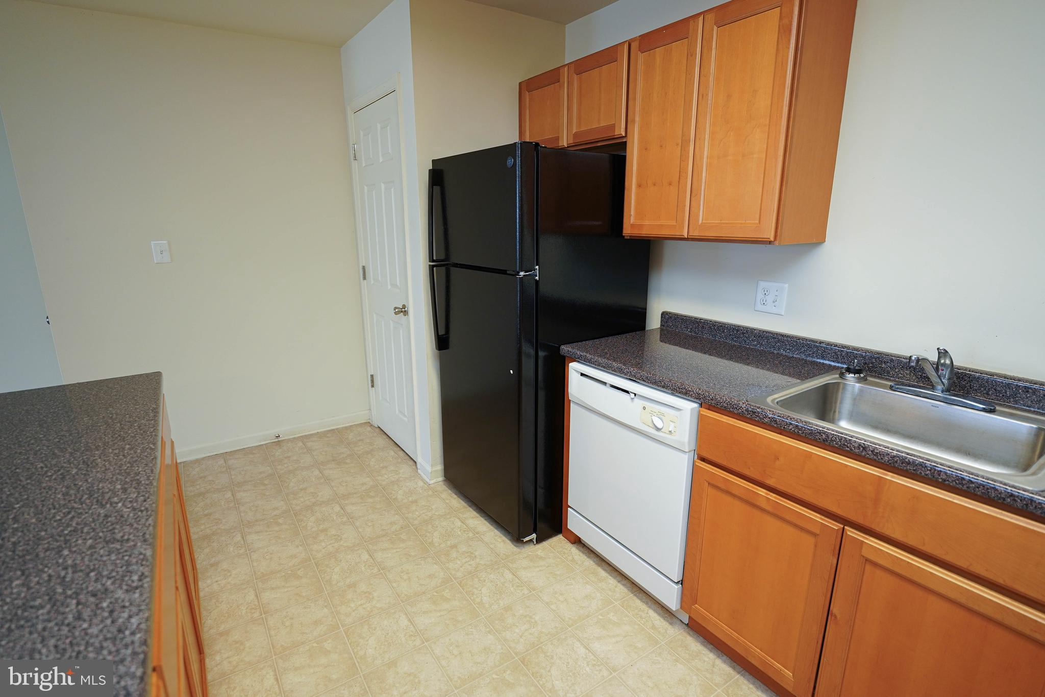 30630 Umes Boulevard, Unit V204 Princess Anne, MD 21853 - Photo 11 of 36 a kitchen with granite countertop white cabinets and refrigerator