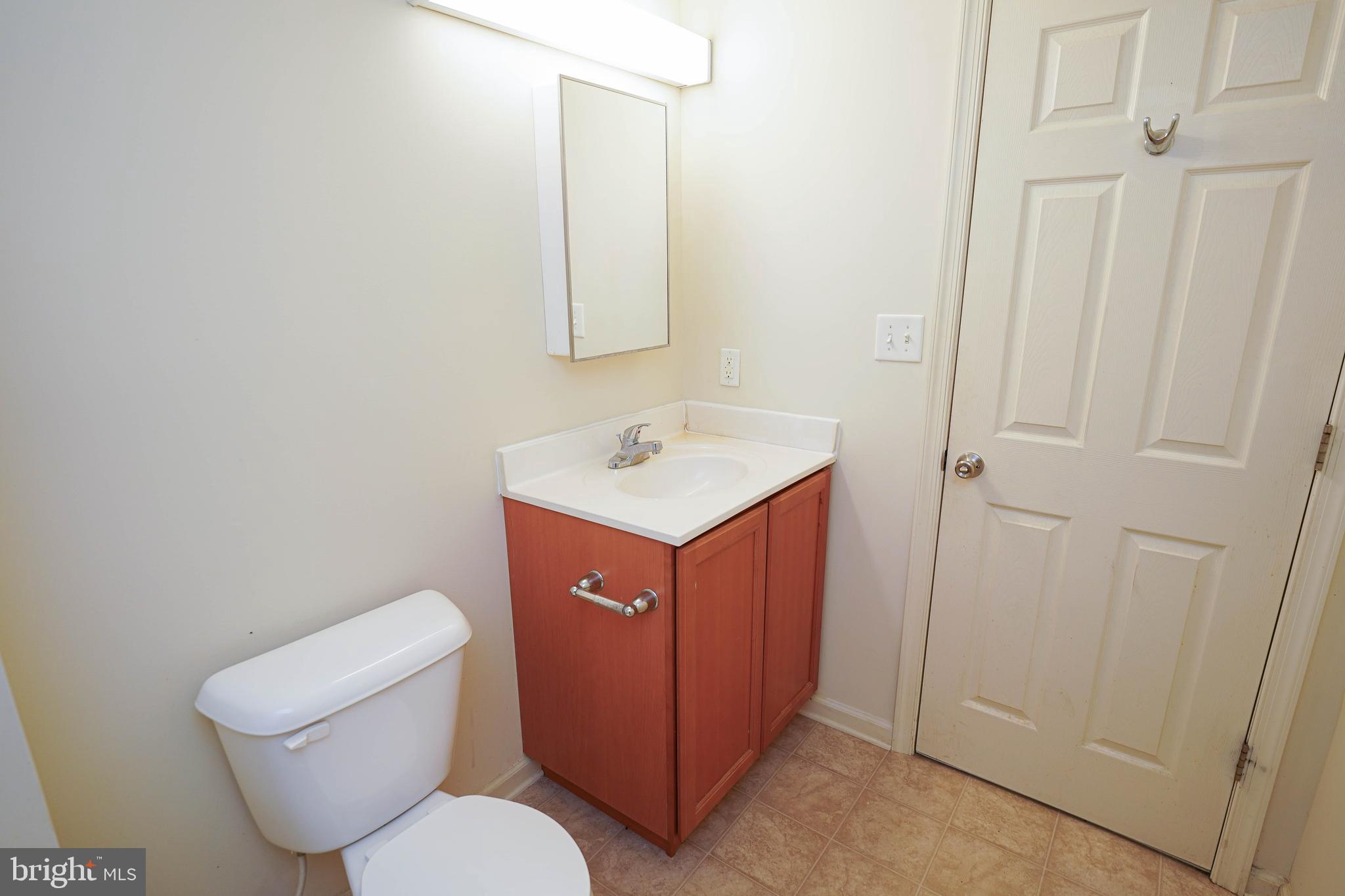 30630 Umes Boulevard, Unit V204 Princess Anne, MD 21853 - Photo 20 of 36 a bathroom with a toilet sink and mirror