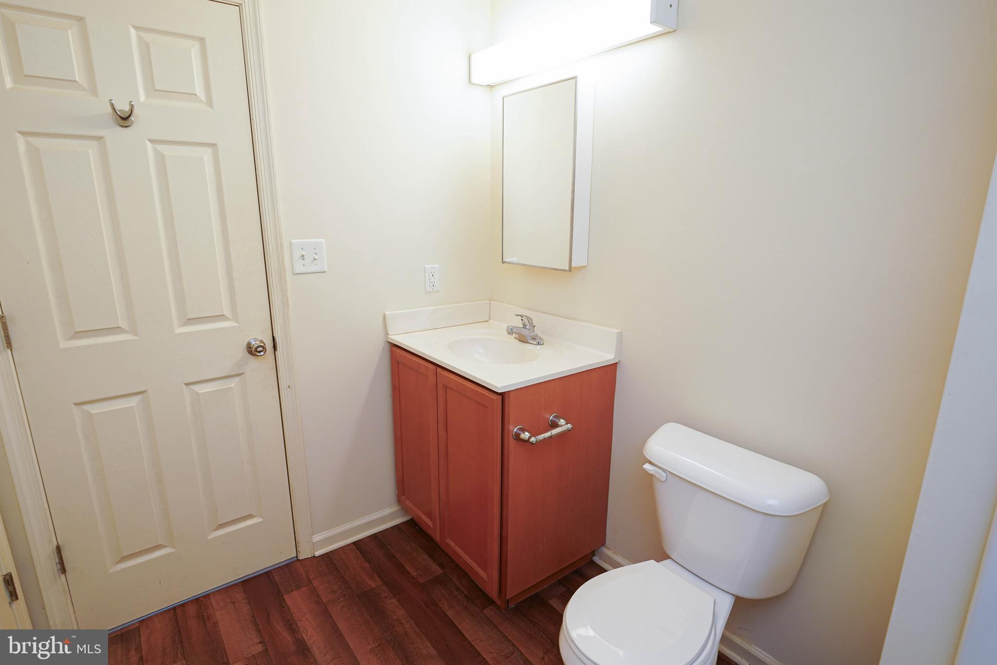 30630 Umes Boulevard, Unit V204 Princess Anne, MD 21853 - Photo 27 of 36 a bathroom with a toilet a sink and mirror