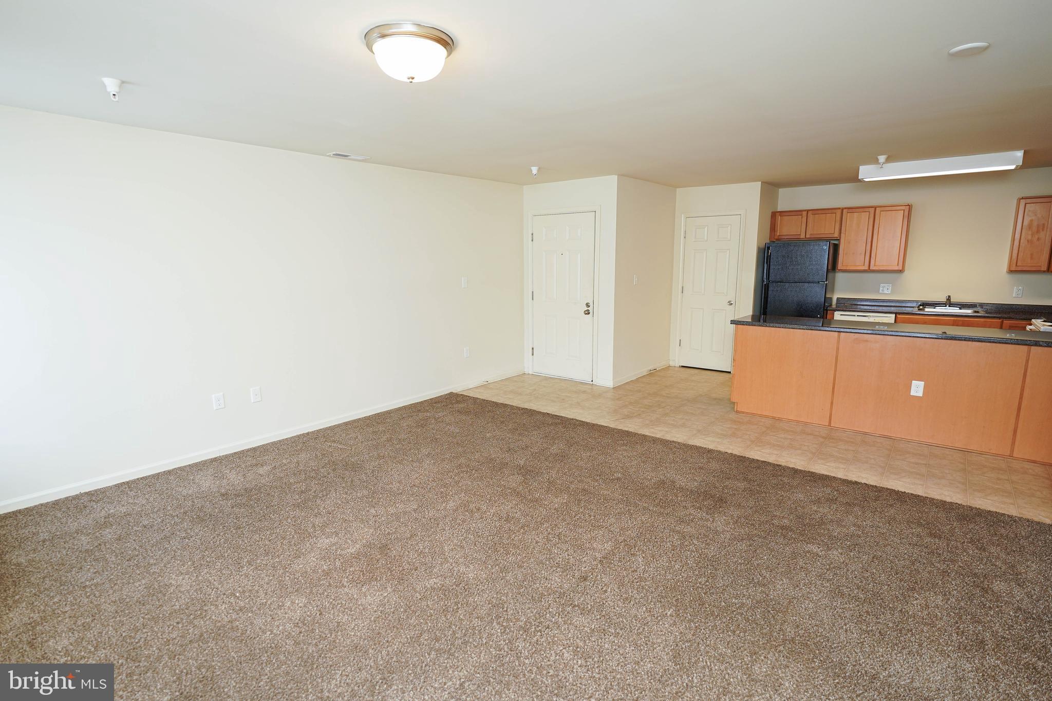30630 Umes Boulevard, Unit V204 Princess Anne, MD 21853 - Photo 7 of 36 a kitchen with granite countertop a sink and white cabinets