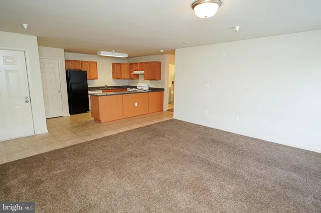 a large kitchen with cabinets and a refrigerator