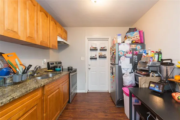 a view of a kitchen with fridge and workspace