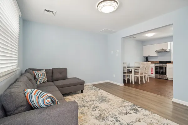 a living room with a couch and wooden floor
