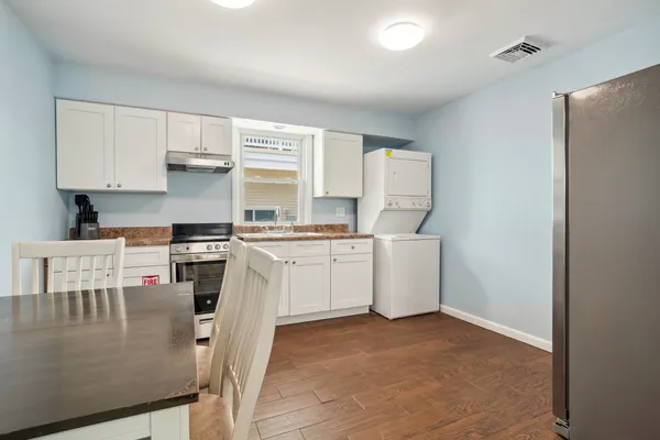a kitchen with white cabinets and white appliances