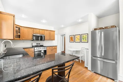 a kitchen with stainless steel appliances granite countertop a stove a refrigerator a sink a stove and island