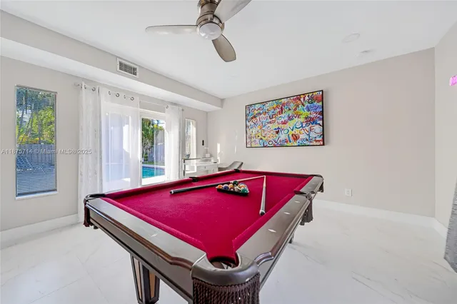 a room with pool table and windows