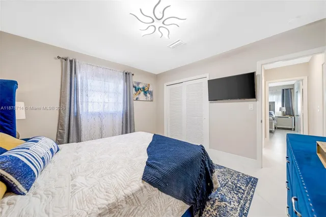 a bedroom with a bed and a flat screen tv