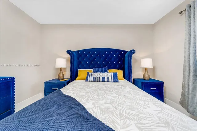 a bedroom with a bed and a lamp on dresser