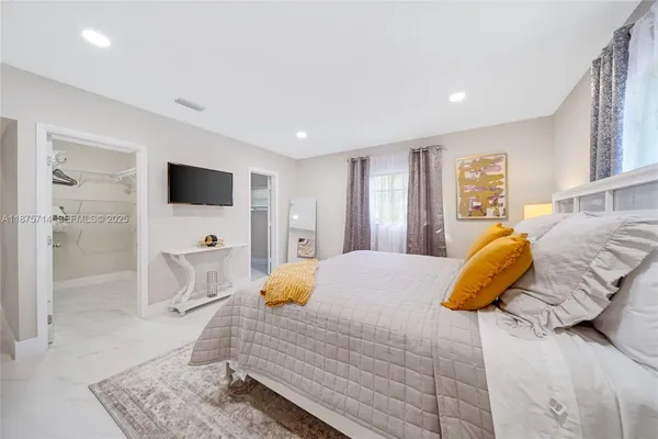 a bedroom with a bed and a flat screen tv