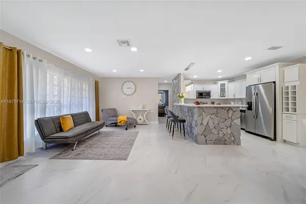 a living room with furniture and kitchen view