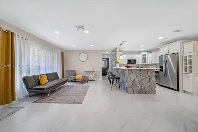 a living room with furniture and kitchen view