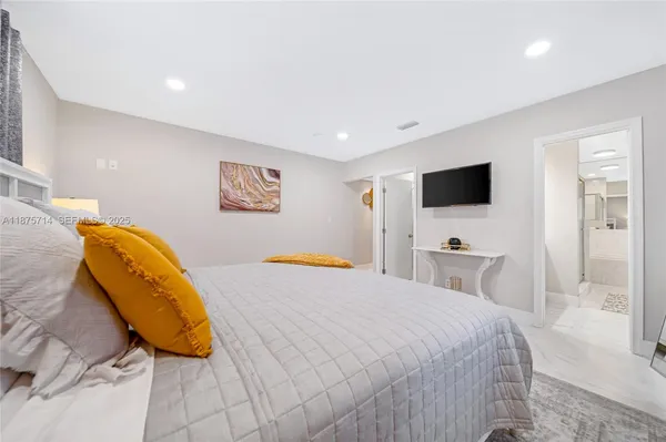 a bedroom with a bed and a flat screen tv