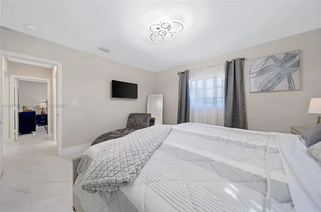 a bedroom with a bed and a flat screen tv