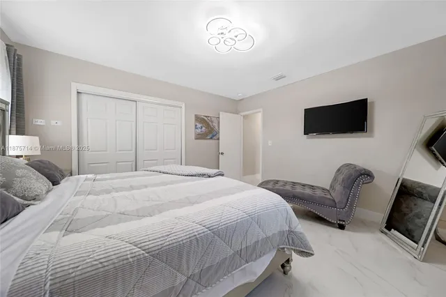 a bedroom with a bed and a flat screen tv