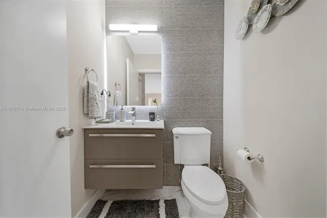 a bathroom with a toilet sink and mirror