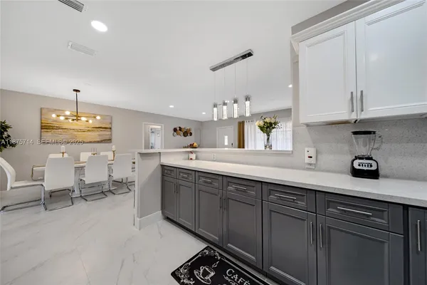 a kitchen with cabinets and chairs