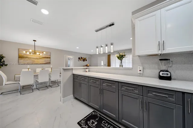 a kitchen with cabinets and chairs