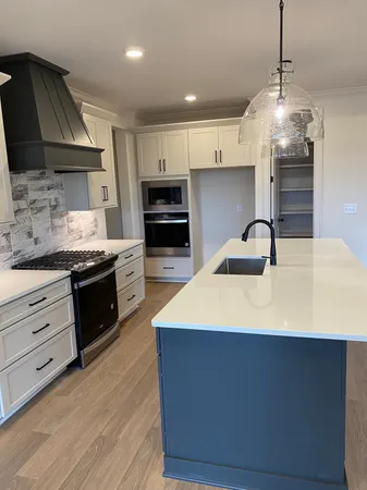 a kitchen with kitchen island granite countertop a sink stainless steel appliances and cabinets