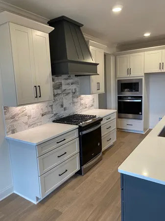 a kitchen with granite countertop a sink cabinets and stainless steel appliances