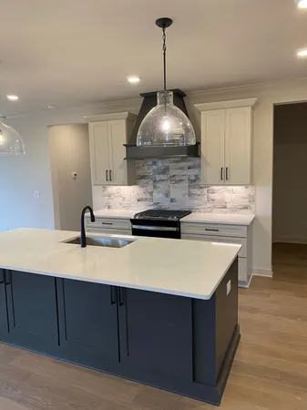a kitchen with a stove and a chandelier
