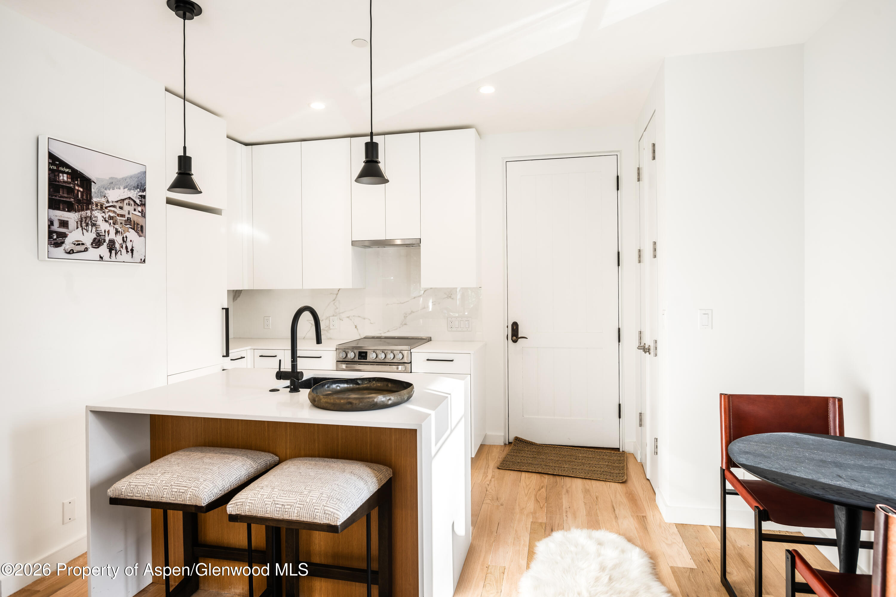 501 West Main Street, Unit A101 Aspen, CO 81611 - Photo 5 of 8 a kitchen with a sink a table and chairs in it