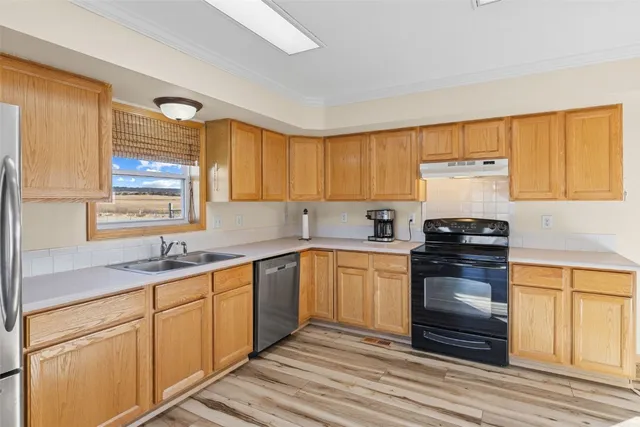 a kitchen with granite countertop cabinets stainless steel appliances a sink and a window