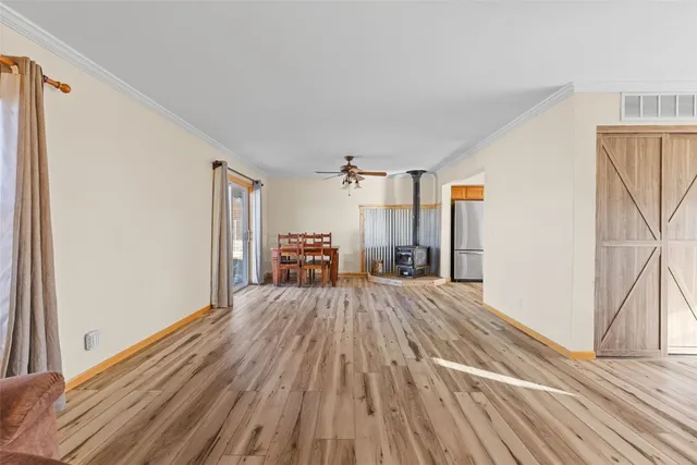 a view of a room with wooden floor fireplace and windows