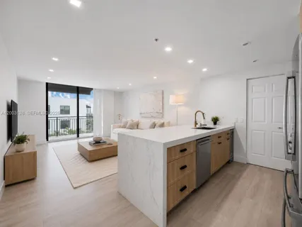 a large white kitchen with a large window