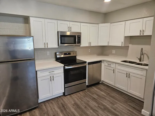 a kitchen with white cabinets stainless steel appliances and sink