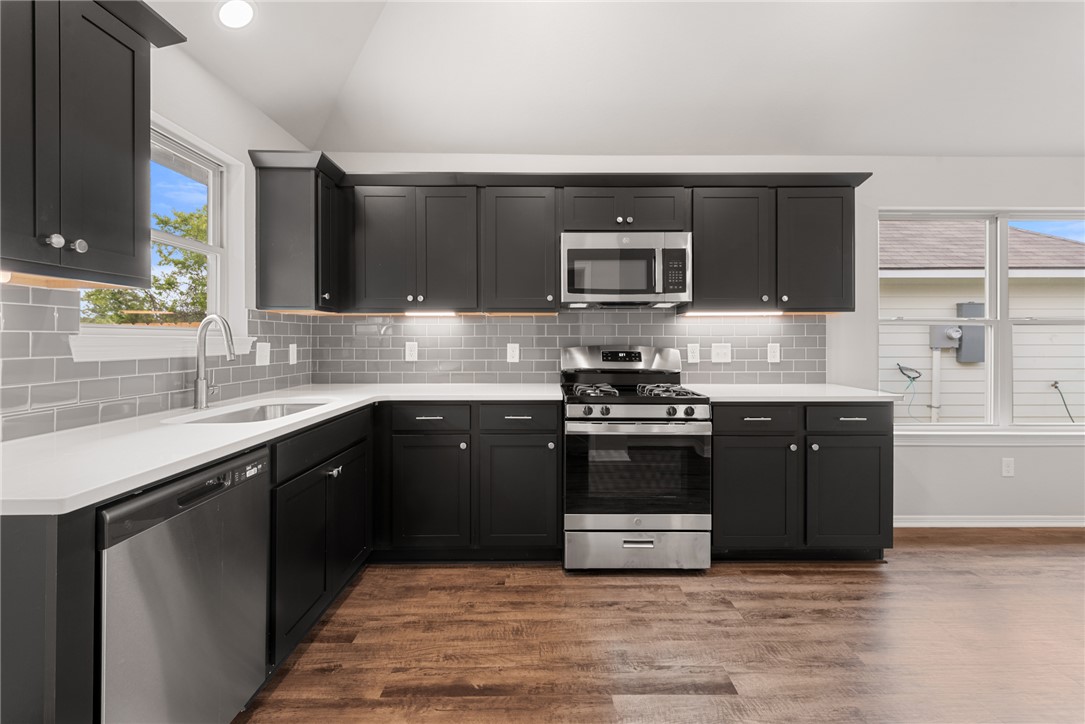 2869 Messenger Way Bryan, TX 77803 - Photo 10 of 23 a kitchen with stainless steel appliances granite countertop a stove a sink and a microwave