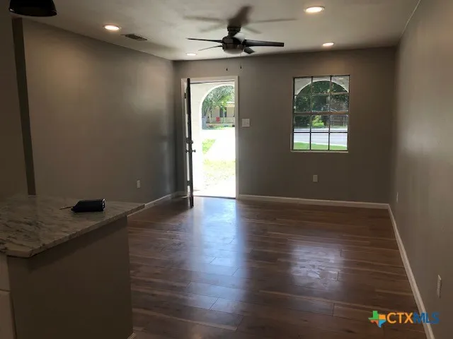 a kitchen with a sink appliances and wooden floor