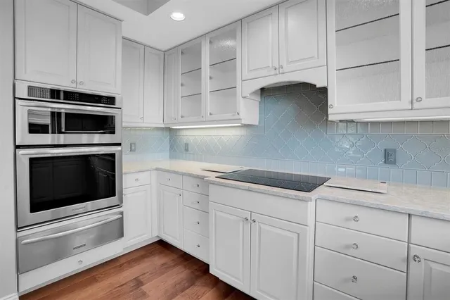 a kitchen with granite countertop a sink stainless steel appliances and cabinets