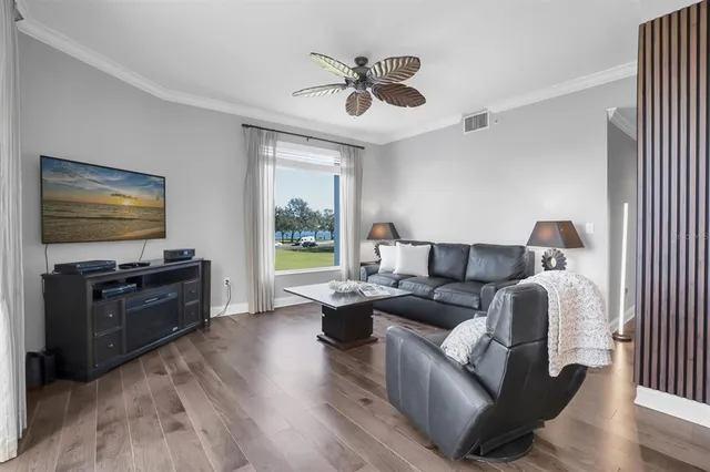 a living room with furniture floor to ceiling window and a flat screen tv