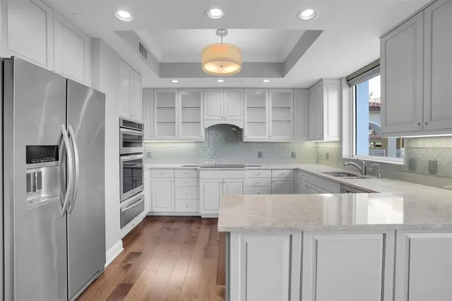 a kitchen with granite countertop a refrigerator and a sink
